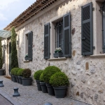 Façade de maison en pierre avec plantes en pots.
